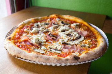 Prosciutto and mushrooms Pizza. Neapolitan pizza with tomato sauce, cheese and prosciutto ham. Authentic Italian recipe.