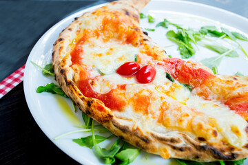 Calzone Pizza. Neapolitan pizza stuffed with cheese, tomato and other ingredients such as meat or vegetables. Authentic Italian recipe.