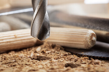 drill bit makes hole in wooden oak board for wooden dowel.