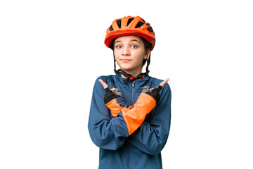 Teenager cyclist girl over isolated chroma key background pointing to the laterals having doubts