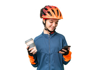 Teenager cyclist girl over isolated chroma key background holding coffee to take away and a mobile - obrazy, fototapety, plakaty