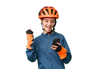 Teenager cyclist girl over isolated chroma key background with phone in victory position