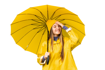 Teenager girl with rainproof coat and umbrella over isolated chroma key background smiling a lot
