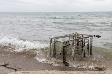 An old shopping cart is disposed of on the shore of Lake Ontario at Marie Curtis Park in Toronto.