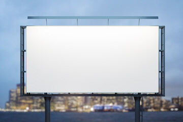 Fototapeta premium Blank white billboard on cityscape background at evening, front view. Mock up, advertising concept