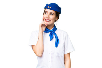 Airplane stewardess over isolated chroma key background thinking an idea while looking up