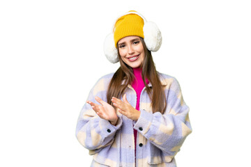 Young woman wearing winter muffs over isolated chroma key background applauding after presentation in a conference