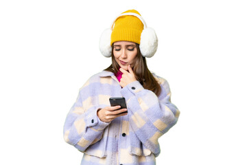 Young woman wearing winter muffs over isolated chroma key background thinking and sending a message