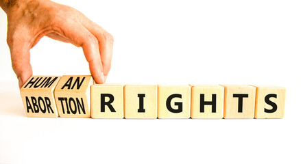 Abortion rights symbol. Concept words Abortion rights are human rights on wooden cubes. Businessman hand. Beautiful white table white background. Business medical abortion rights concept. Copy space.