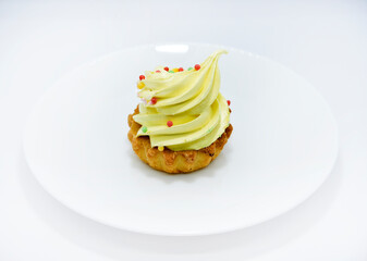 Delicious colorful cakes on a plate. Cream cakes on a white background. Shortbread cakes.