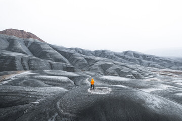 Anonymous backshot orange jacket adventurer in cold tundra