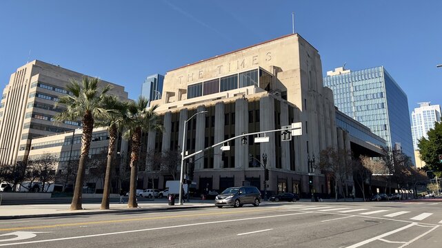 LOS ANGELES, CA, DEC 2022: wide view Los Angeles Times Building with LA Police Department headquarters behind it in Civic Center area, Downtown. Palm trees on corner in foreground