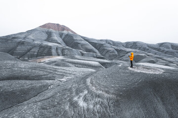 Anonymous backshot orange jacket adventurer in cold tundra