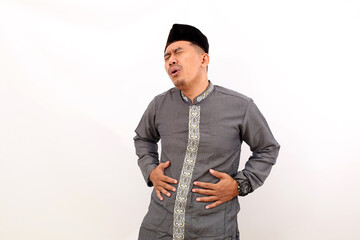 Asian muslim man suffering from stomach ache. Isolated on white background