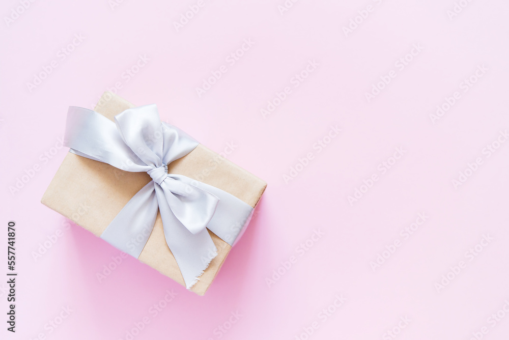 Sticker Rectangular gift box with silver ribbon on plain light pink background