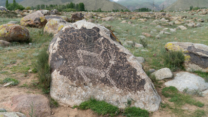 Petroglyph in Kyrgyzstan. An ancient rock carving and engraving known as petroglyphs created by...