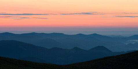 Silhouettes of mountains. Panoramic view of mountain peaks at dawn.