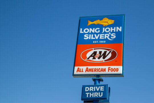 Litchfield, Illinois, USA - March 26, 2022: Close up of Long John Silver’s and A and W restaurant pole sign with blue sky in background. 