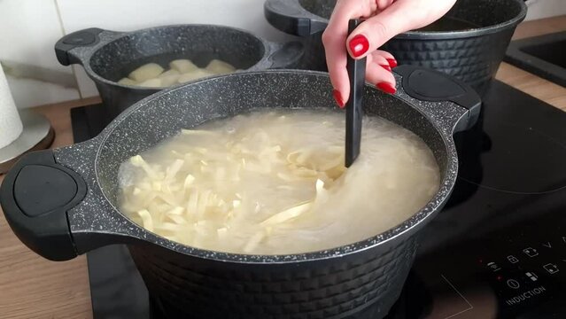 Process of cooking pasta in a pot of hot water on a stove. Food preparation, culinary concept