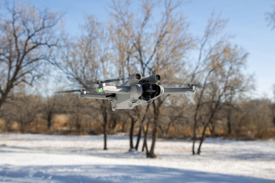 Quadcopter professional imaging aerial uav drone close up with snow and trees in background in a mini form factor
