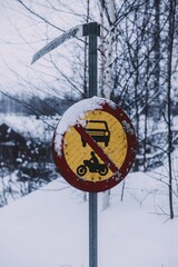 Snowy street sign with car and bike in winter landscape
