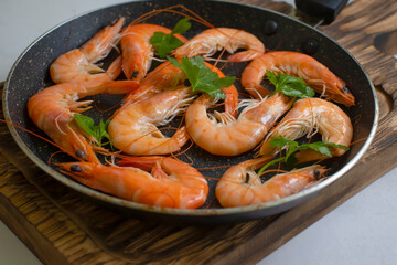 Shrimp in a pan, parsley, on a light background