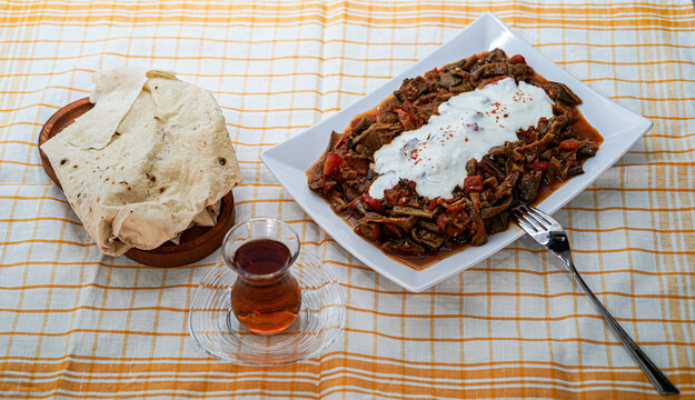 Boiled and sauteed dried long green pepper and eggplant food with yoghurt and tomatoe sauce, turkish tea and turkish yufka bread (a kind of thin tortilla which made in tandoori)