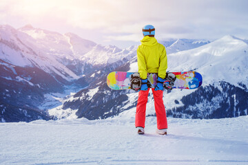Fototapeta na wymiar Girl snowboarder enjoys the winter ski resort.