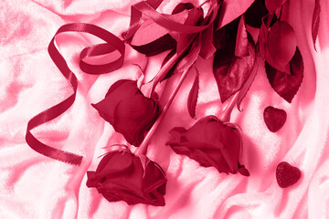 Valentines day surprise. Red roses and hearts on bed. Top view flat lay. Trendy color of year 2023 - Viva Magenta.