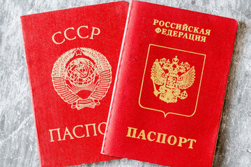Old soviet era red passport and russian passport nearby.