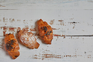 Croissants on a white wooden background.