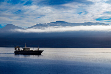 Fishing boat sailing into the port of Neskaupstadur in the fjord of North Iceland