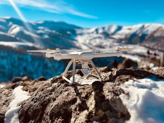 quadrocopter stands on a stone in the mountains in winter