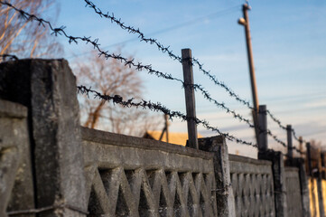 concrete fence with barbed wire