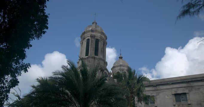 Antigua Caribbean palm trees clouds St Johns Cathedral clock tower fa. Church of Diocese North Eastern Caribbean and Aruba. Anglican Church of England. Originally built 1683. Seventy foot twin towers.
