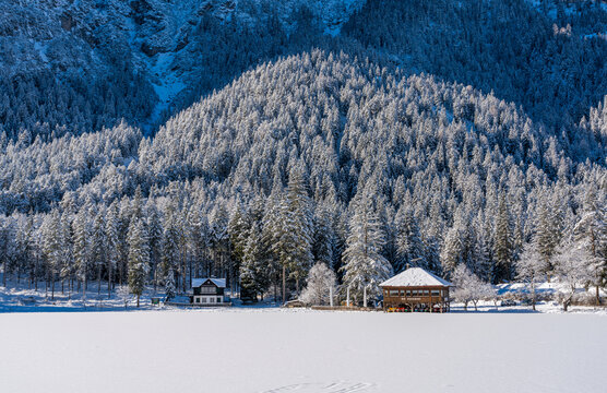 A sunny winter morning at a snowy and iced Lake Dobbiaco, Province of Bolzano, Trentino Alto Adige, Italy.