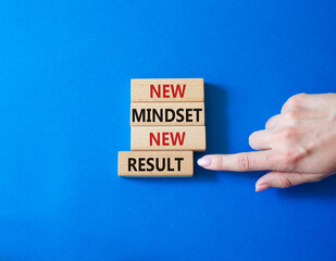 Mindset symbol. Wooden blocks with words New Mindset new Result. Businessman hand. Beautiful blue background. Business and New Mindset new Result concept. Copy space.