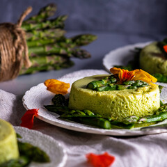 Asparagus custard garnished with asparagus spears and nasturtium petals.