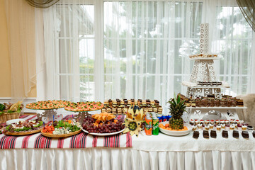 Exquisite festive table with sweets and fruits.