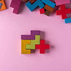Obraz premium Colorful wooden blocks folding on pink background.