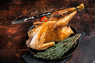 Roast guinea fowl with herbs and spices, cooked game bird. Dark background. Top view