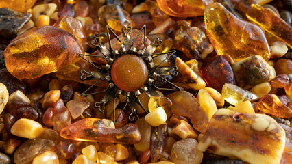 Old Baltic amber brooch on amber stones close up.  Shiny amber jewelry. Amber texture. 