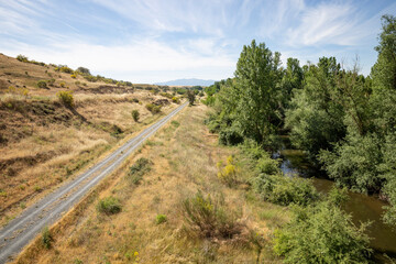 Fototapeta na wymiar Camino Natural Via Verde del Valle del Eresma - gravel road along Eresma river next to Los Huertos, province of Segovia, Castile and León, Spain