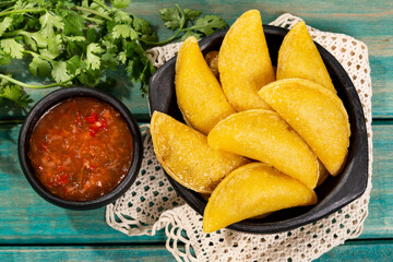 Colombian Empanada With Hot Sauce On Wooden Background.
