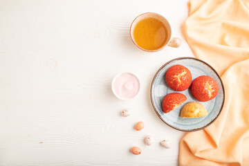 French custard dessert shu cake and cup of green tea on white wooden, top view, copy space.