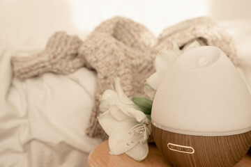 Spa composition with aroma diffuser and lily flowers close-up.