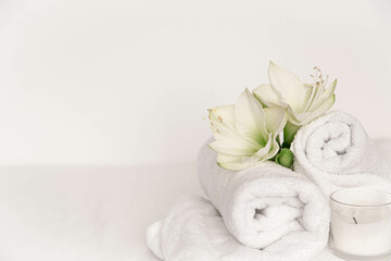 Spa composition with lily flowers and towels on a white background.