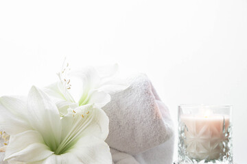 Close-up, lily flowers, candle and towel on a white background isolated.