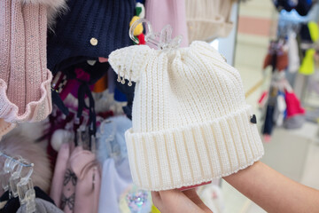 Crochet brown hat in female hands. Woman holding a knitting hat in her hands.