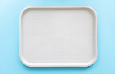 White tray on a blue background, flat lay.